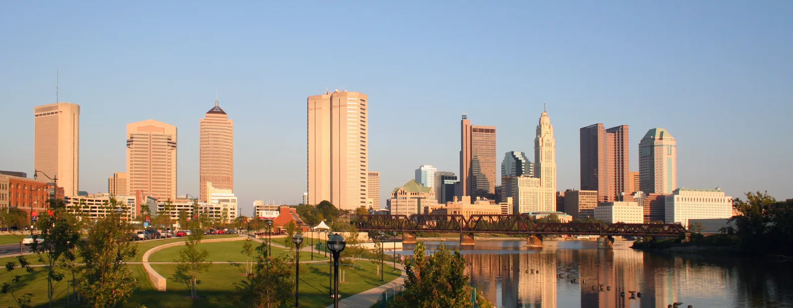 Downtown Columbus at golden hour, seen across the Scioto River from the west bank.